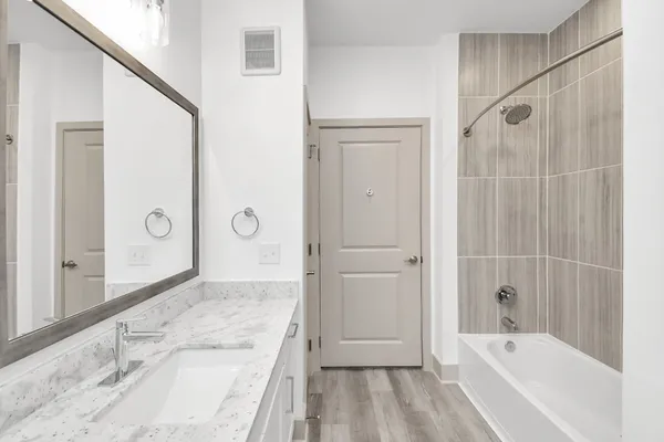 a bathroom with a granite countertop sink a toilet and shower