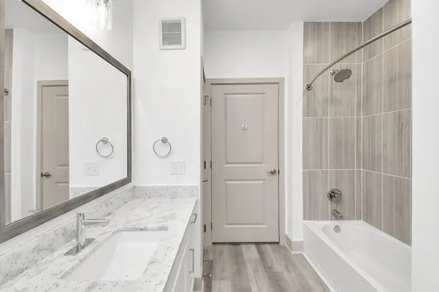 a bathroom with a granite countertop sink a toilet and shower