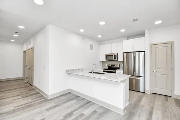a kitchen with stainless steel appliances granite countertop a refrigerator and a stove