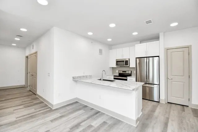 a kitchen with stainless steel appliances granite countertop a refrigerator and a stove