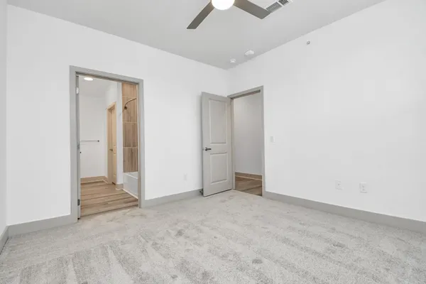 an empty room with chandelier fan