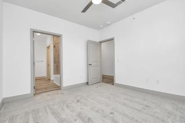 an empty room with chandelier fan