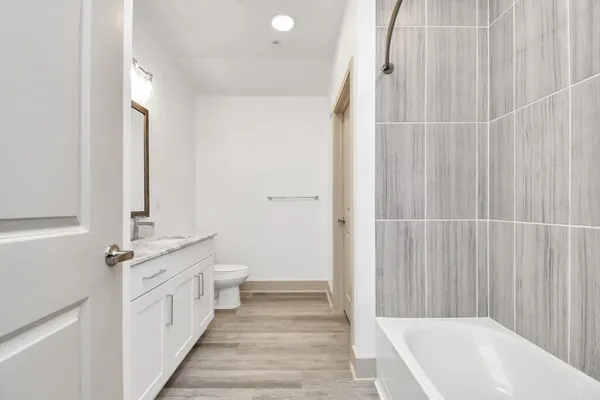 a bathroom with a double vanity sink a toilet and a tub