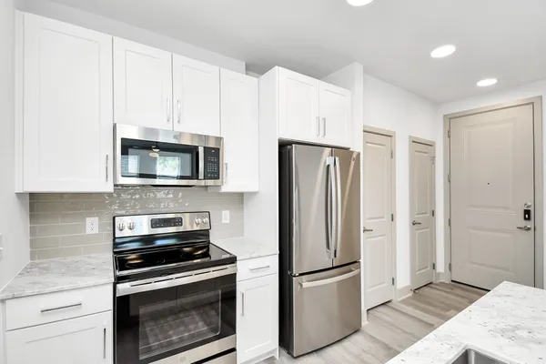 a kitchen with white cabinets and stainless steel appliances