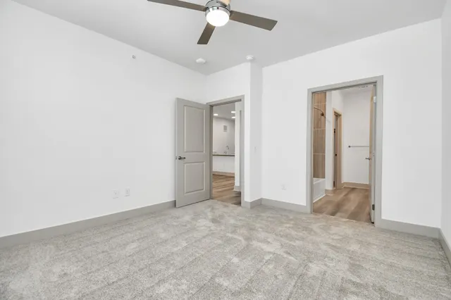 an empty room with fan and entrance