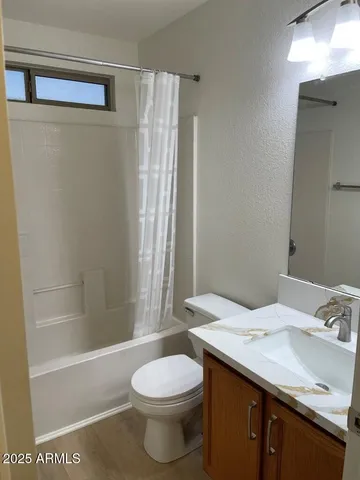 an empty room with a window and a ceiling fan