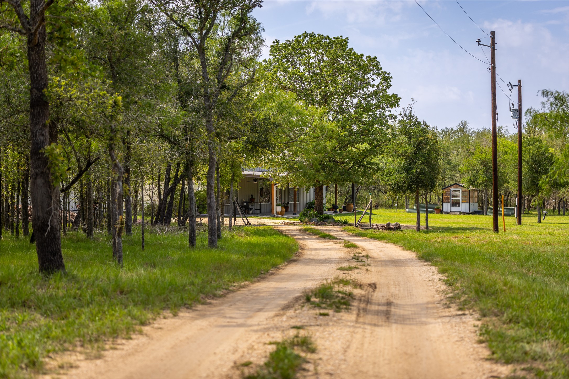 4082 Old Colony Line Road Lockhart, TX 78644 - Photo 18 of 40 Discover a tranquil retreat nestled among mature trees, offering a private, rural setting.