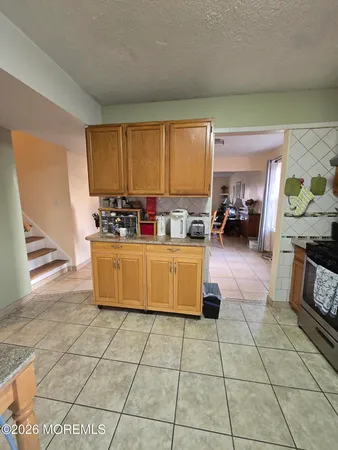 a kitchen with a sink a counter and a stove top oven