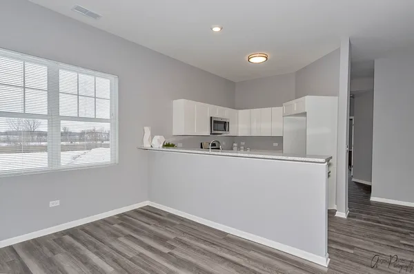 a kitchen with granite countertop a stove a sink and a microwave
