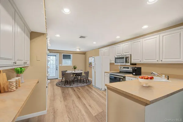 a kitchen that has a lot of cabinets a sink and appliances in it