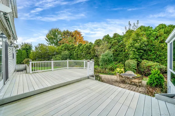 a view of a deck with wooden floor and fence with a bench