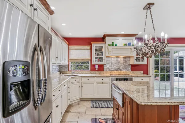 a kitchen with stainless steel appliances granite countertop a sink and a refrigerator
