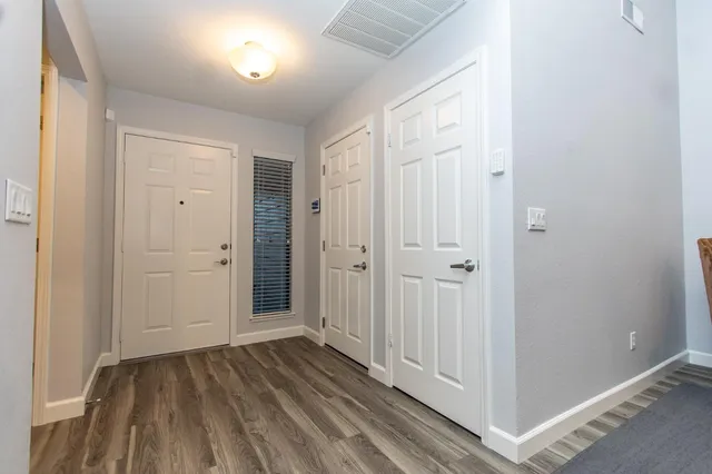 a view of a hallway with wooden floor and closet area