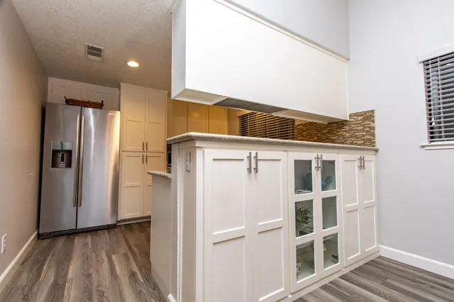 a view of a refrigerator in kitchen and wooden floor