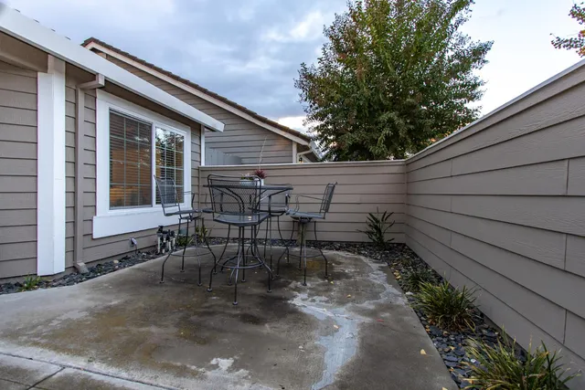 a backyard of a house with table and chairs