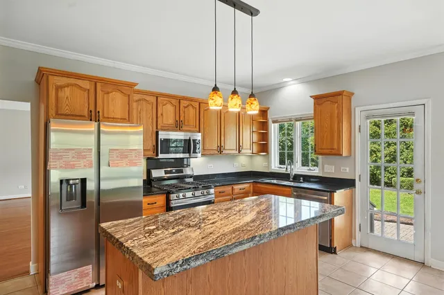 a kitchen with a sink a counter top space appliances and a chandelier