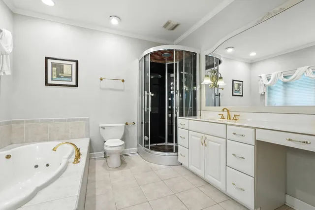 a spacious bathroom with a double vanity sink a toilet and a bathtub