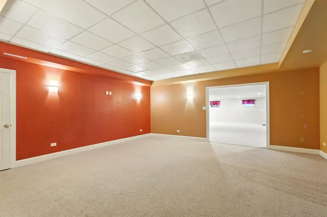 a view of an empty room with a chandelier fan