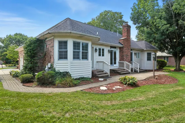 a front view of a house with a yard and trees