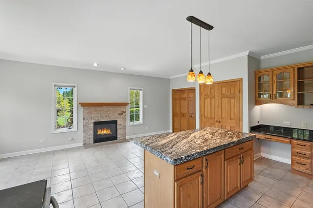 a kitchen with kitchen island granite countertop a stove and a sink