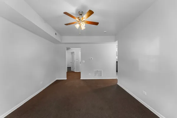 an empty room with a ceiling fan and window