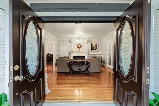 a dining room with furniture a chandelier and wooden floor