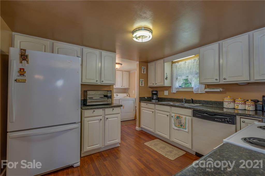 400 Howard Cole Road Rutherfordton, NC 28139 - Photo 7 of 29 a kitchen with a refrigerator a stove a sink wooden floor and cabinets