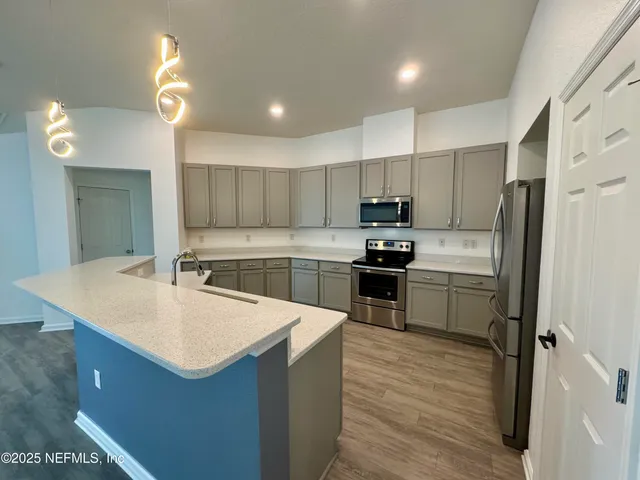 a kitchen with a refrigerator a sink a stove a microwave and island