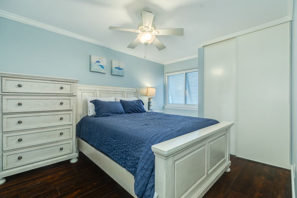 7516 Stewart Road Galveston, TX 77551 - Photo 19 of 25 a bedroom with a bed and a chandelier