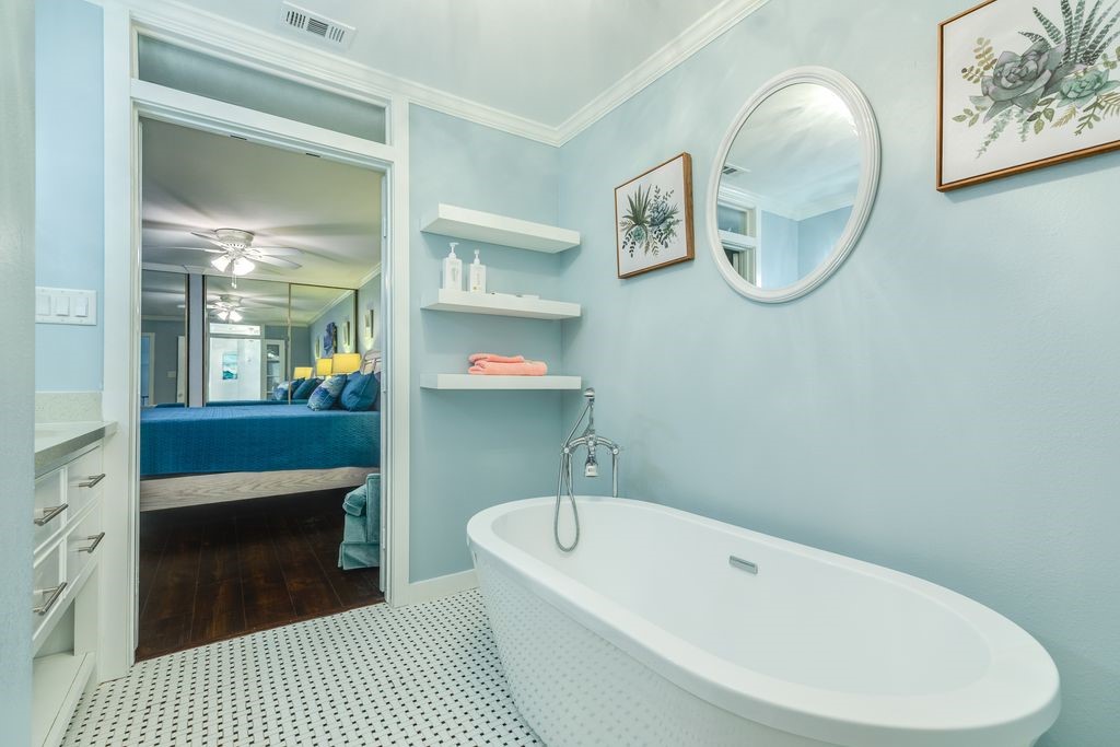 7516 Stewart Road Galveston, TX 77551 - Photo 21 of 25 a bathroom with a bathtub a sink and a mirror