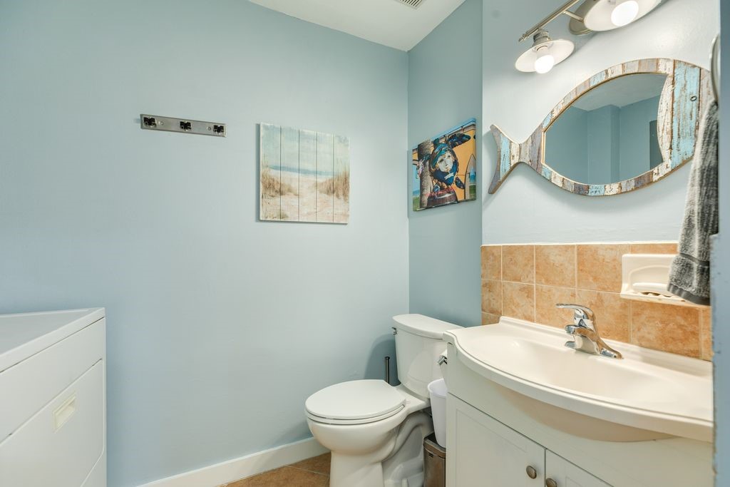 7516 Stewart Road Galveston, TX 77551 - Photo 24 of 25 a bathroom with a toilet sink and mirror
