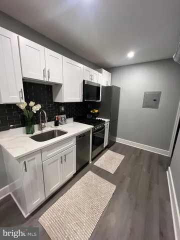 a kitchen with a sink cabinets and wooden floor