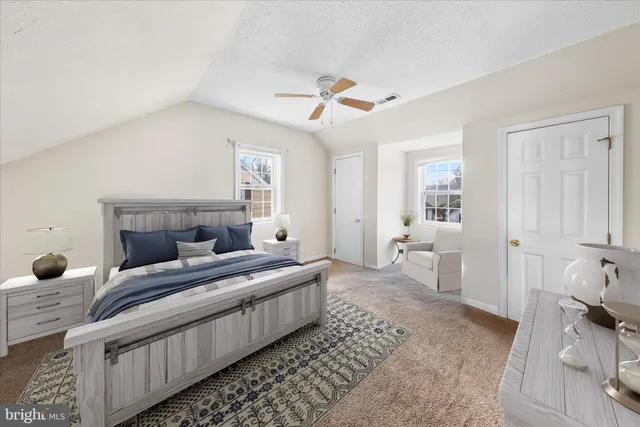 a view of a big room with windows and chandelier fan