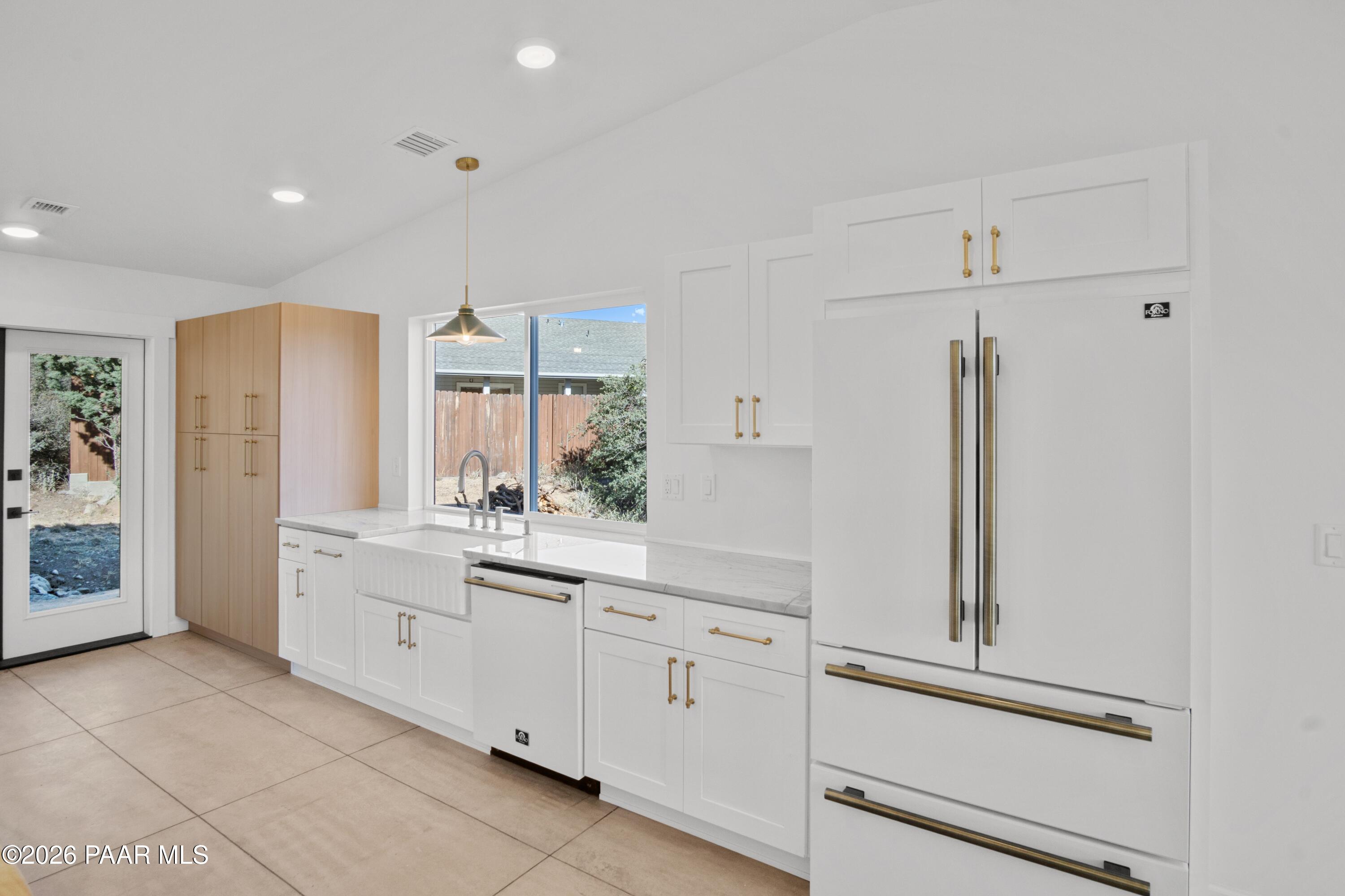 4920 East Amber Road Prescott, AZ 86301 - Photo 6 of 38 a kitchen with white cabinets and white appliances
