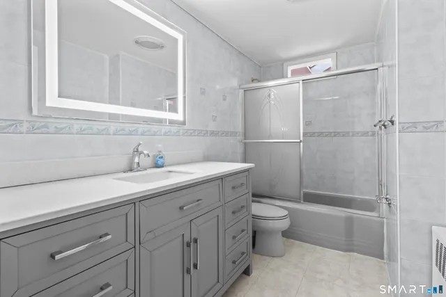 a bathroom with a double vanity sink toilet and shower