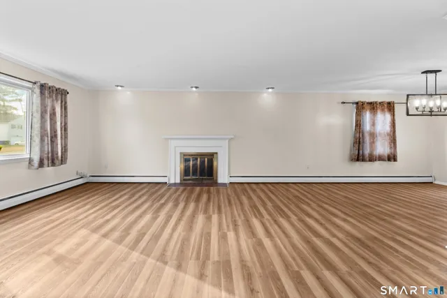 wooden floor in an empty room with a fireplace