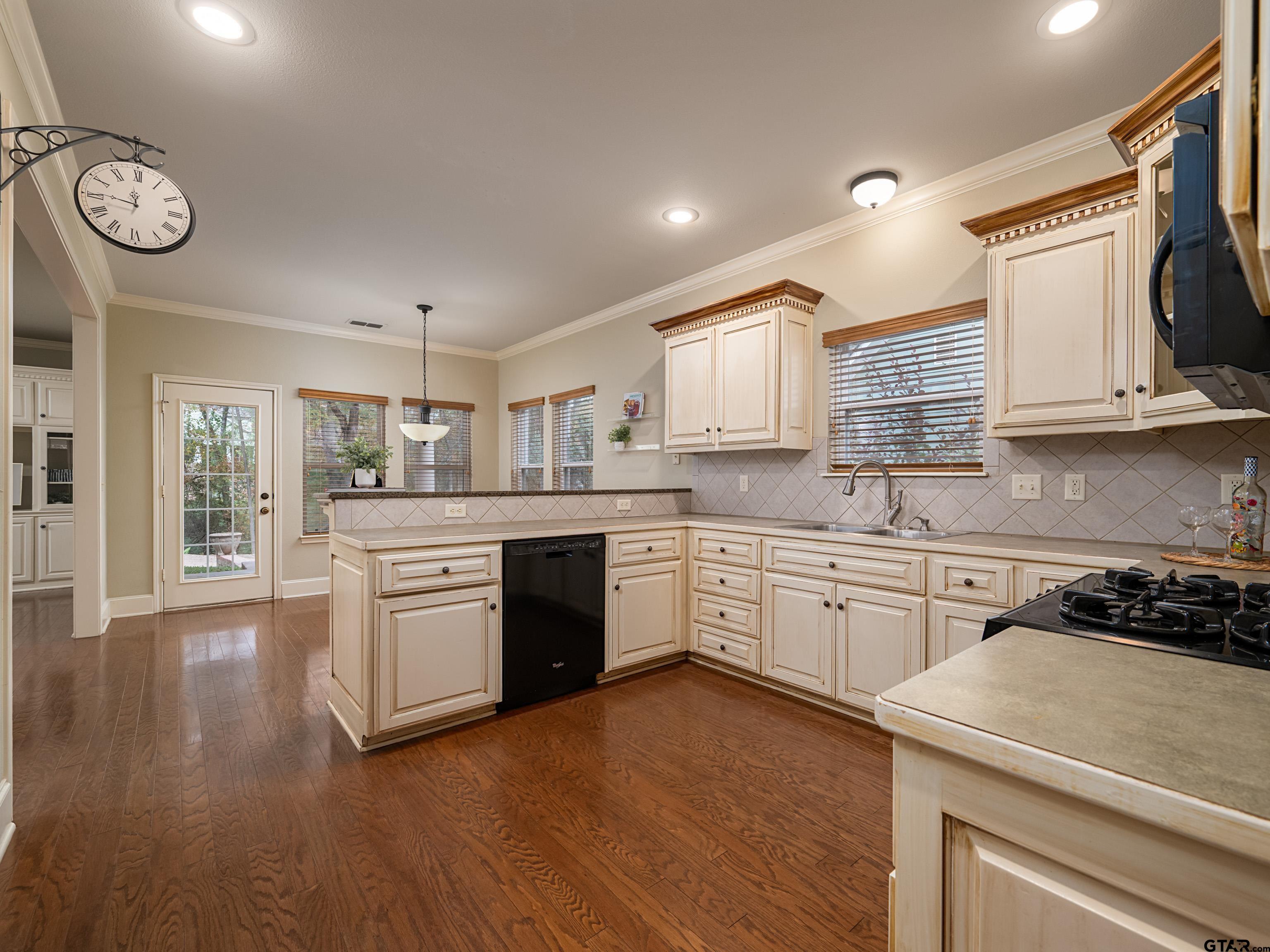 3950 Hanover Place Tyler, TX 75701 - Photo 11 of 44 a kitchen with granite countertop a stove a sink and a microwave