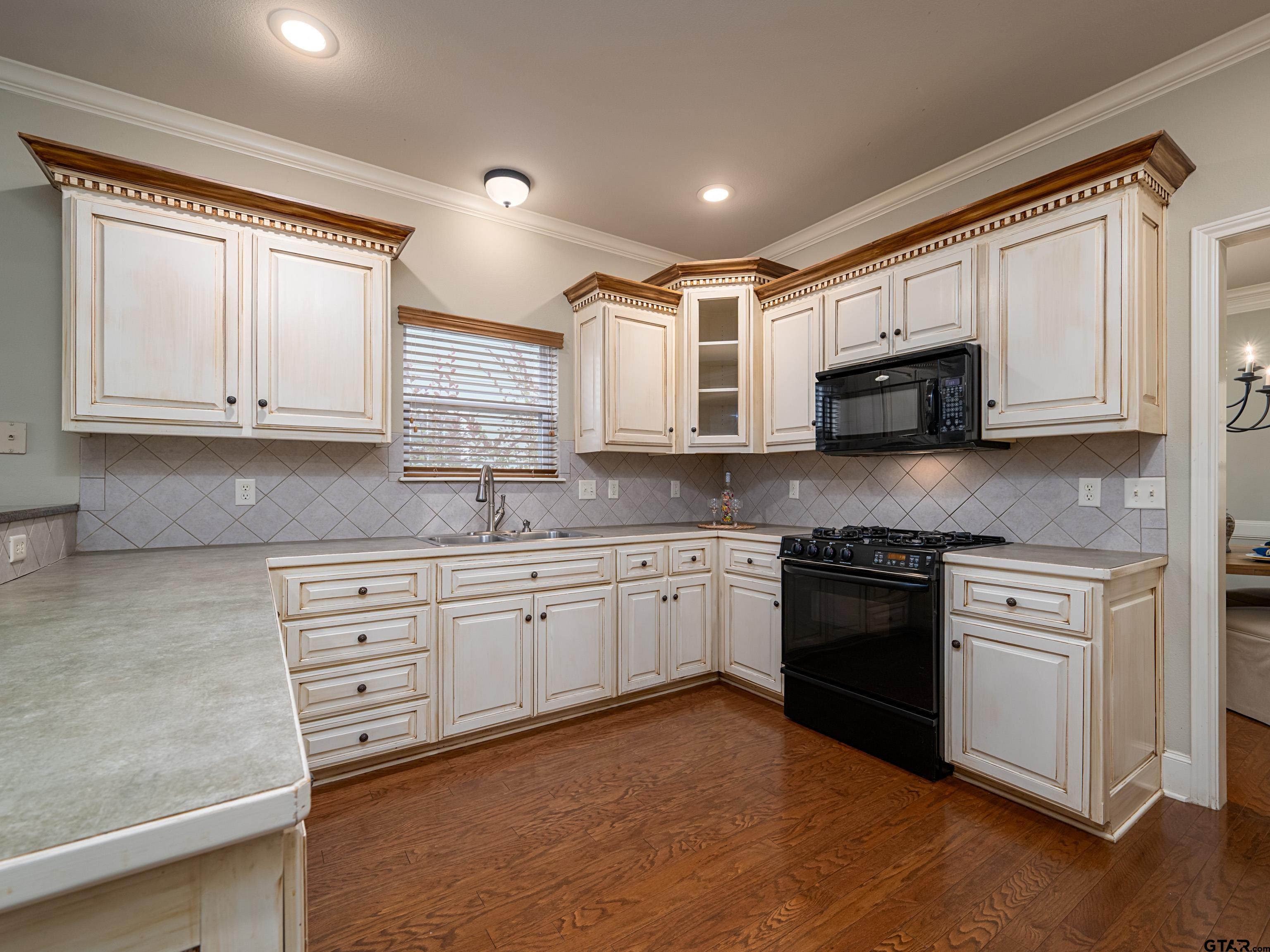 3950 Hanover Place Tyler, TX 75701 - Photo 12 of 44 a kitchen with stainless steel appliances granite countertop a stove a sink and a microwave