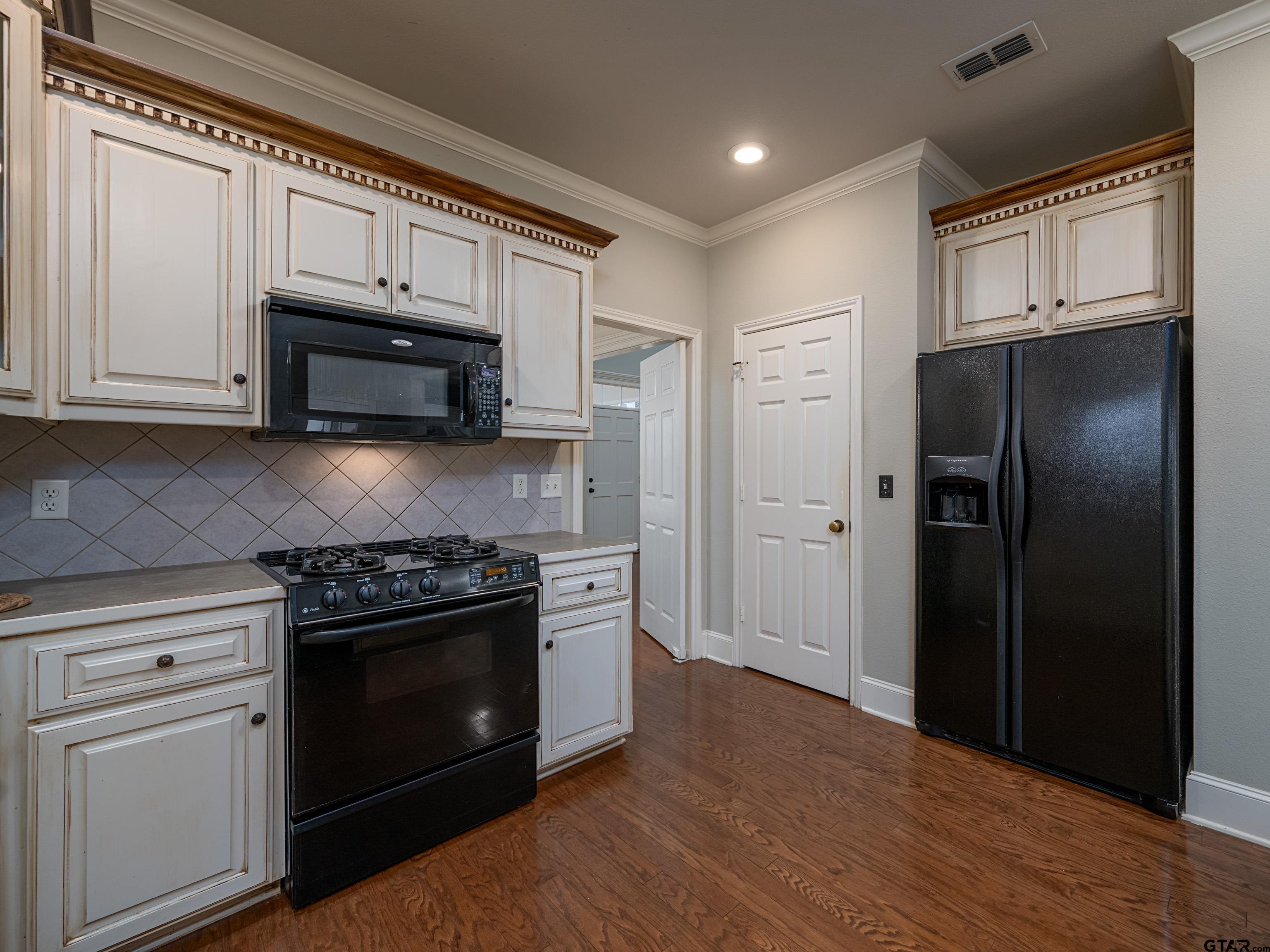 3950 Hanover Place Tyler, TX 75701 - Photo 13 of 44 a kitchen with stainless steel appliances granite countertop a stove a refrigerator and a microwave