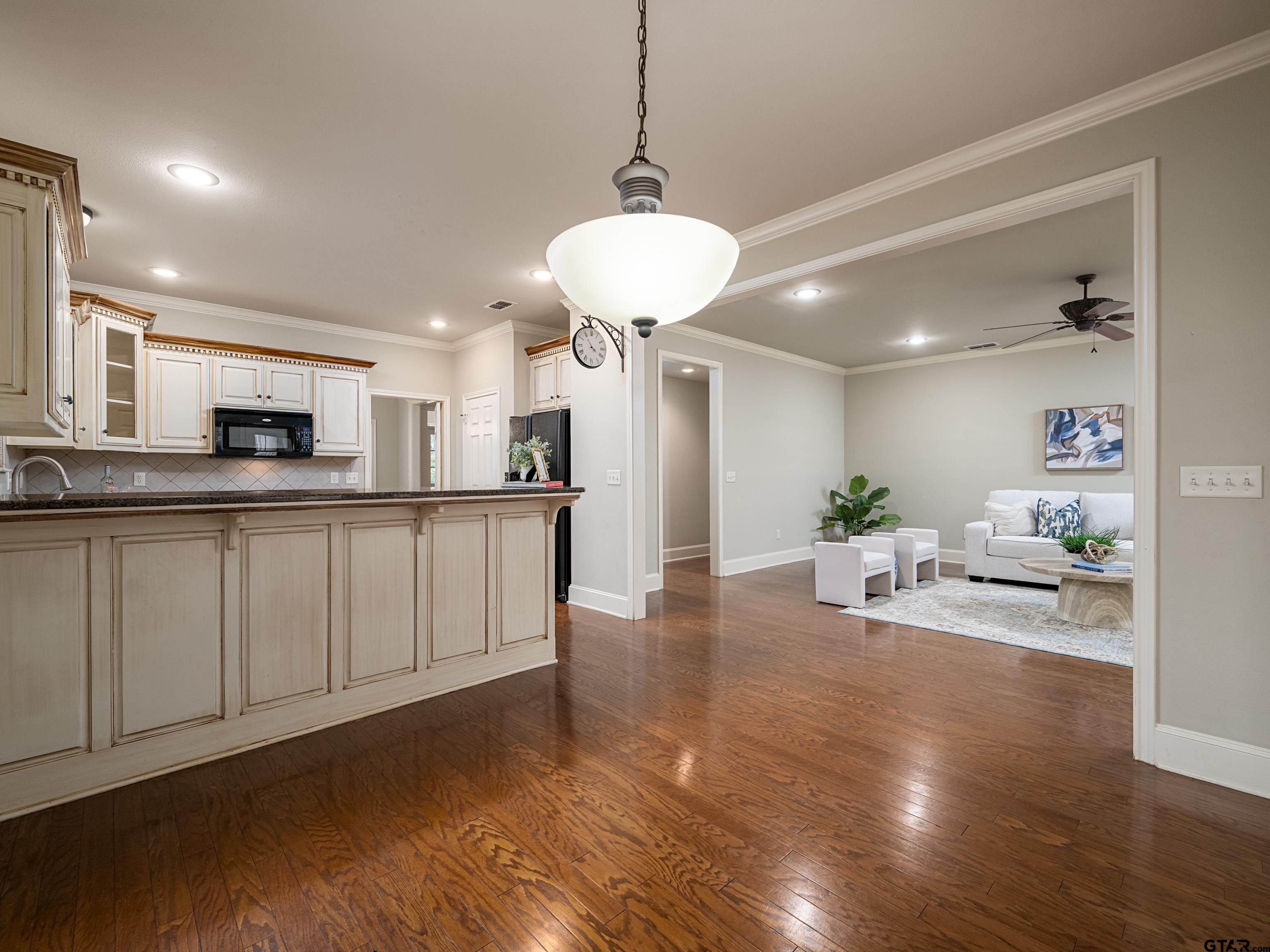 3950 Hanover Place Tyler, TX 75701 - Photo 15 of 44 a kitchen with stainless steel appliances granite countertop a refrigerator a sink dishwasher and white cabinets with wooden floor