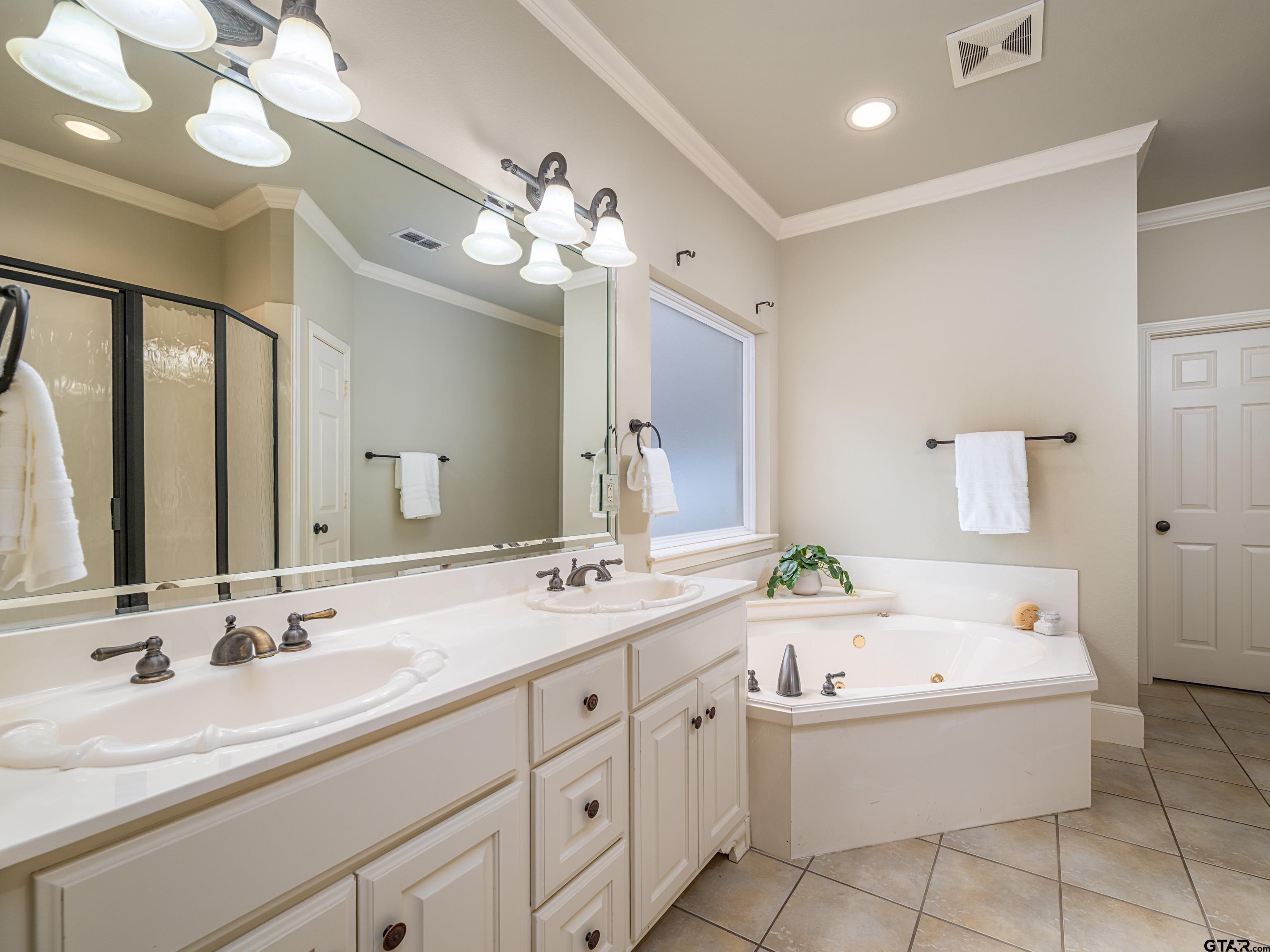 3950 Hanover Place Tyler, TX 75701 - Photo 20 of 44 a bathroom with a tub a sink double and a mirror