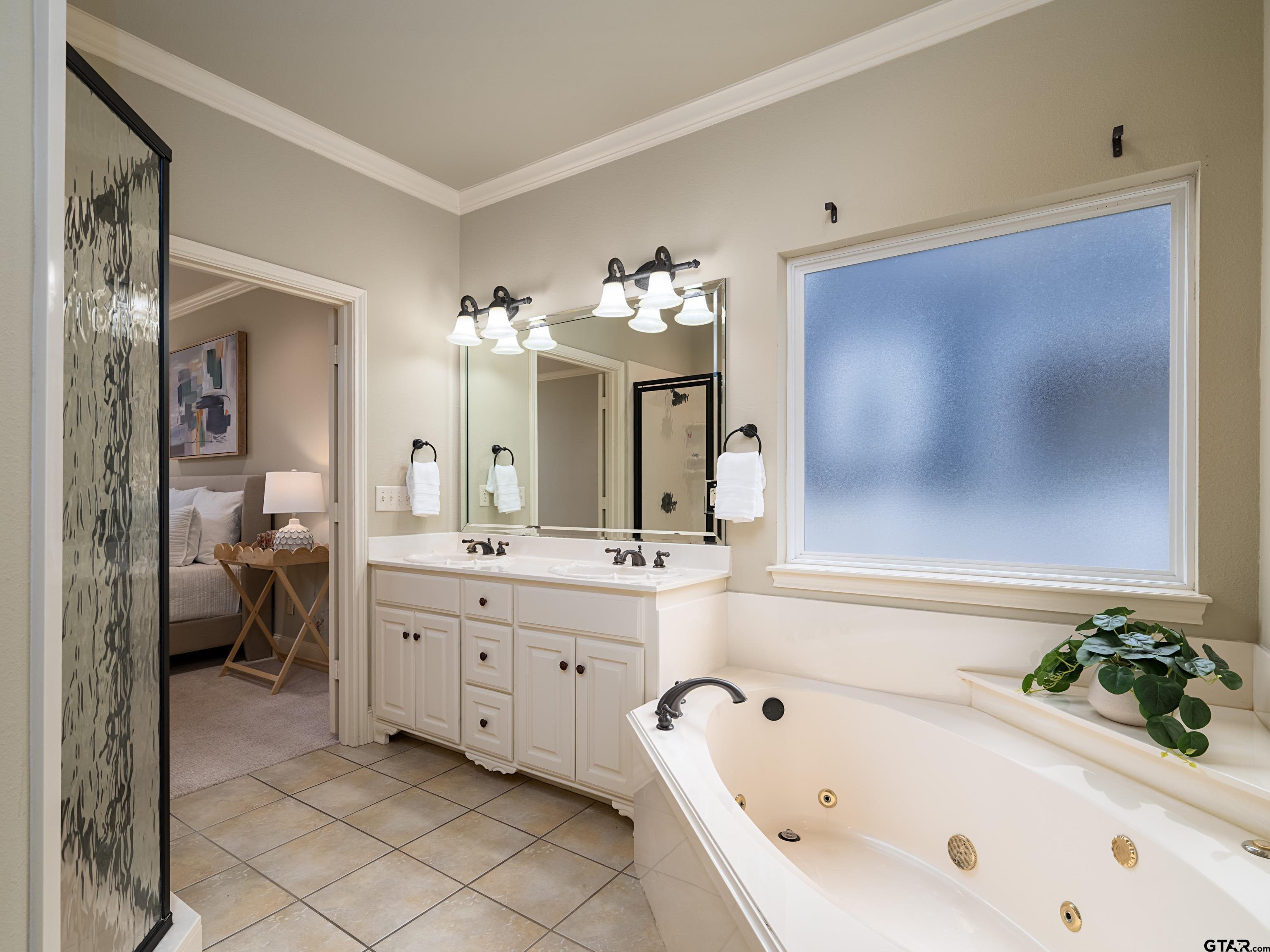 3950 Hanover Place Tyler, TX 75701 - Photo 21 of 44 a spacious en suite bathroom with a tub sink and mirror