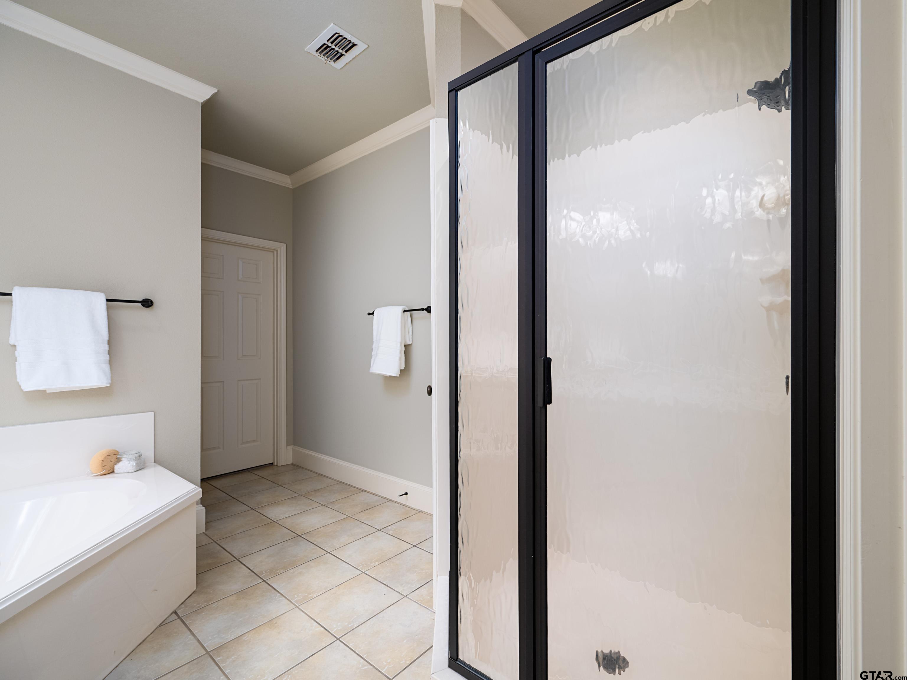 3950 Hanover Place Tyler, TX 75701 - Photo 22 of 44 a bathroom with a bathtub and a shower