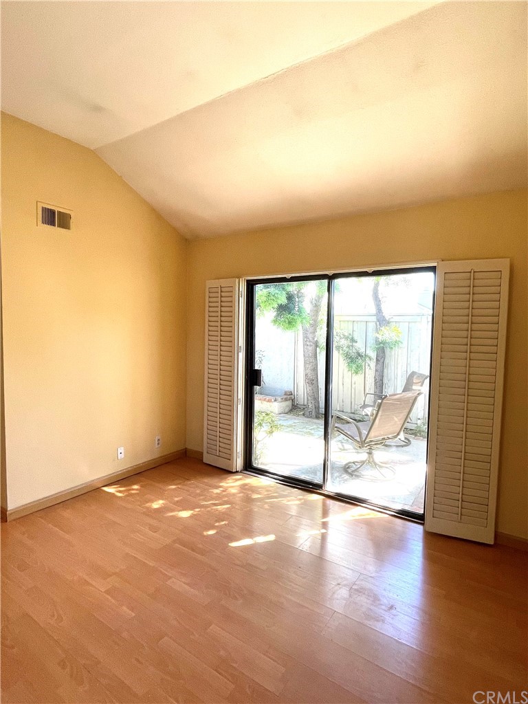 48 Riverstone, Unit 60 Irvine, CA 92606 - Photo 13 of 31 a view of an empty room with wooden floor and a window