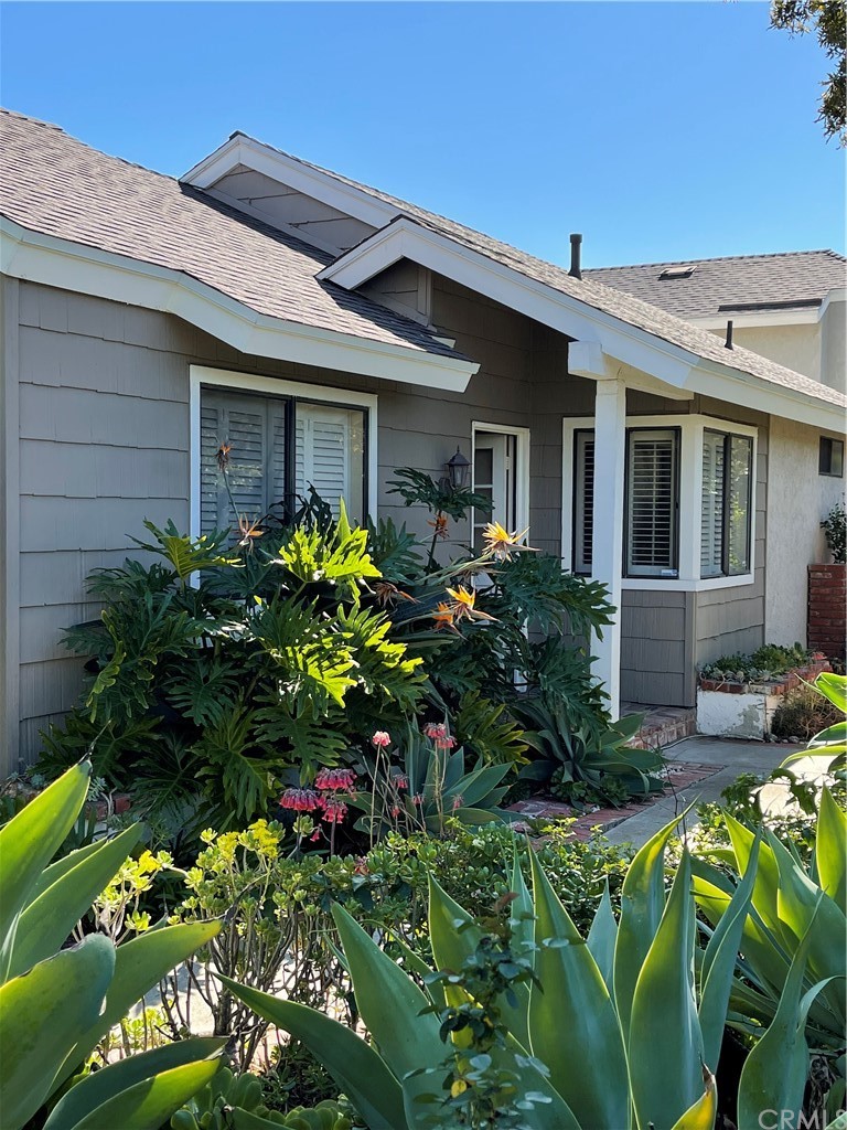 48 Riverstone, Unit 60 Irvine, CA 92606 - Photo 2 of 31 a front view of a house with a lot of flower around