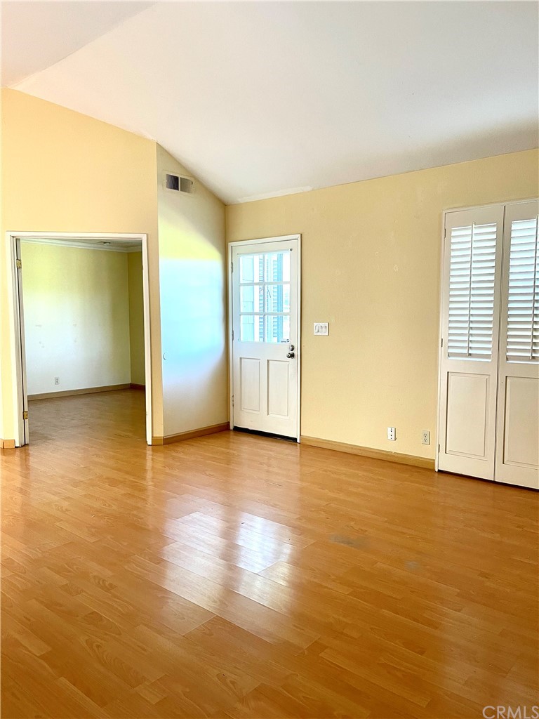48 Riverstone, Unit 60 Irvine, CA 92606 - Photo 8 of 31 an empty room with wooden floor and windows