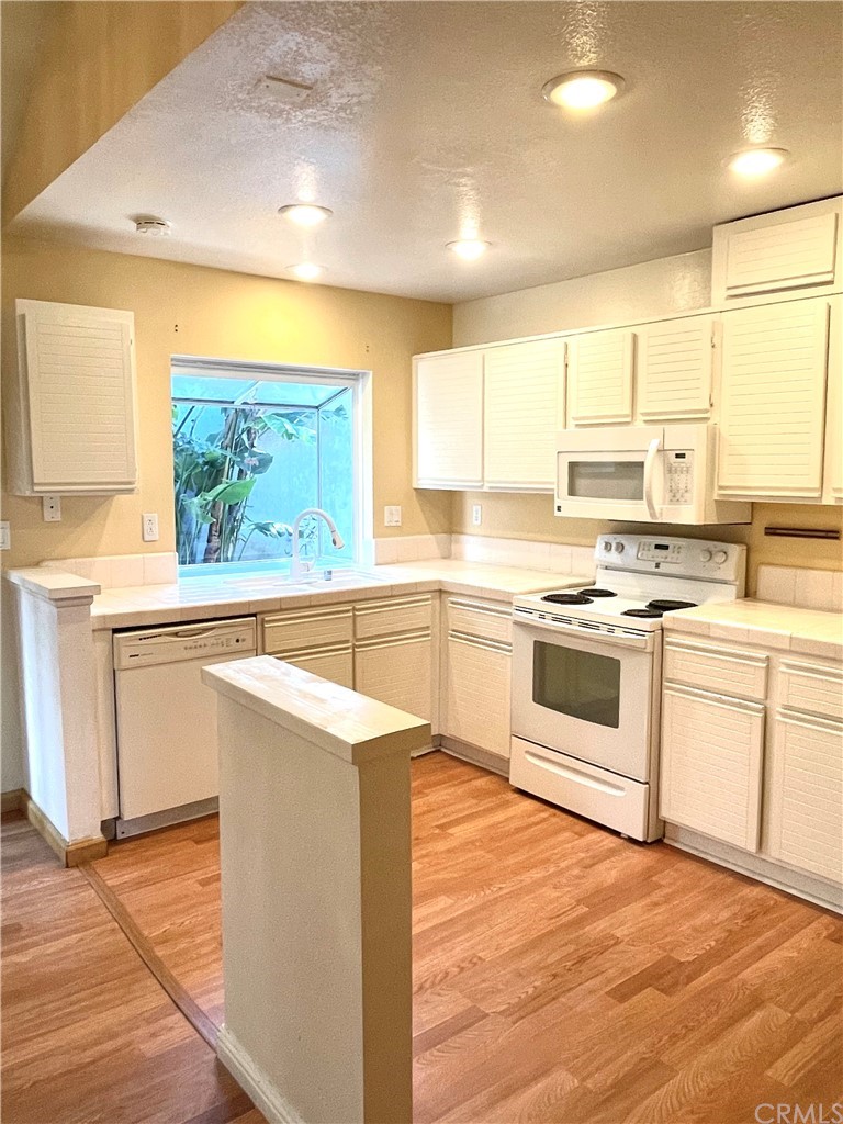 48 Riverstone, Unit 60 Irvine, CA 92606 - Photo 9 of 31 a kitchen with stainless steel appliances a white stove top oven sink and window