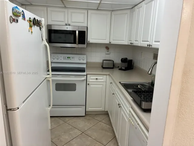 a kitchen with stainless steel appliances granite countertop a sink a stove a microwave and cabinets