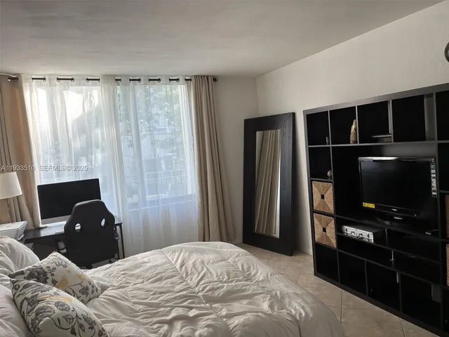 a large bed sitting in a bedroom next to a window and dresser