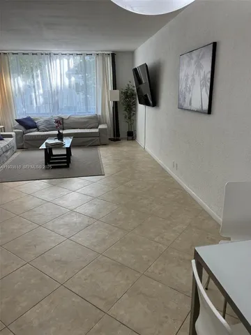 a dining room with furniture and a chandelier fan